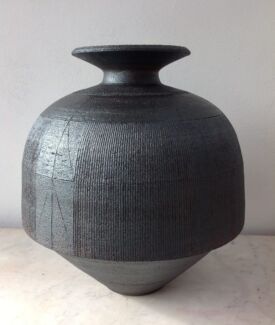 Hemispherical urn with flaring rim. Close parallel scoring. 50cm./20”